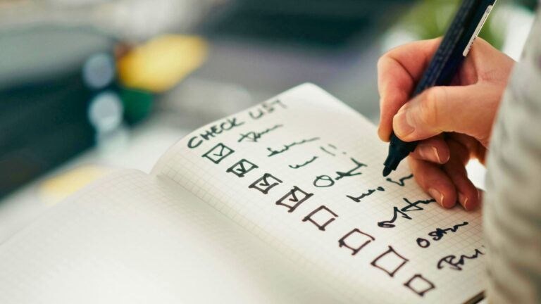 michigan home buying checklist person writing notes in a notebook with pen marker