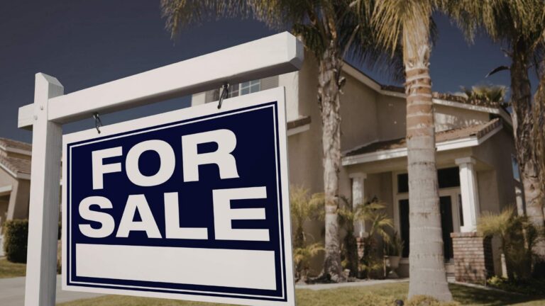 blue for sale sign in front of tropical home location